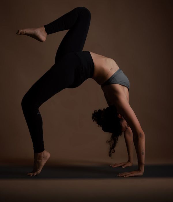Woman in a calm yoga pose against a dark, serene background.